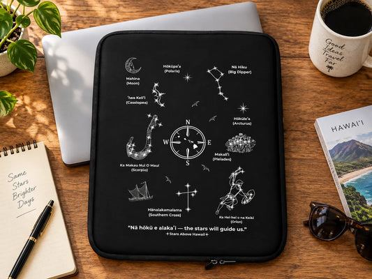 Black Hawaiʻi Star Navigation laptop sleeve with celestial wayfinding artwork beside a silver laptop on a wooden desk