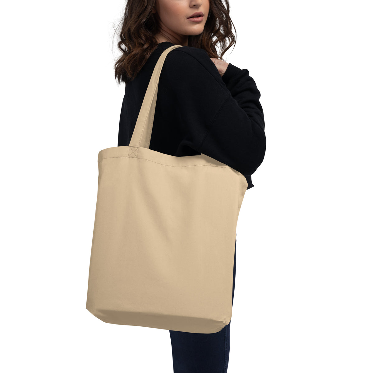 Woman carrying the reverse side of a natural beige Rising Star organic cotton tote bag