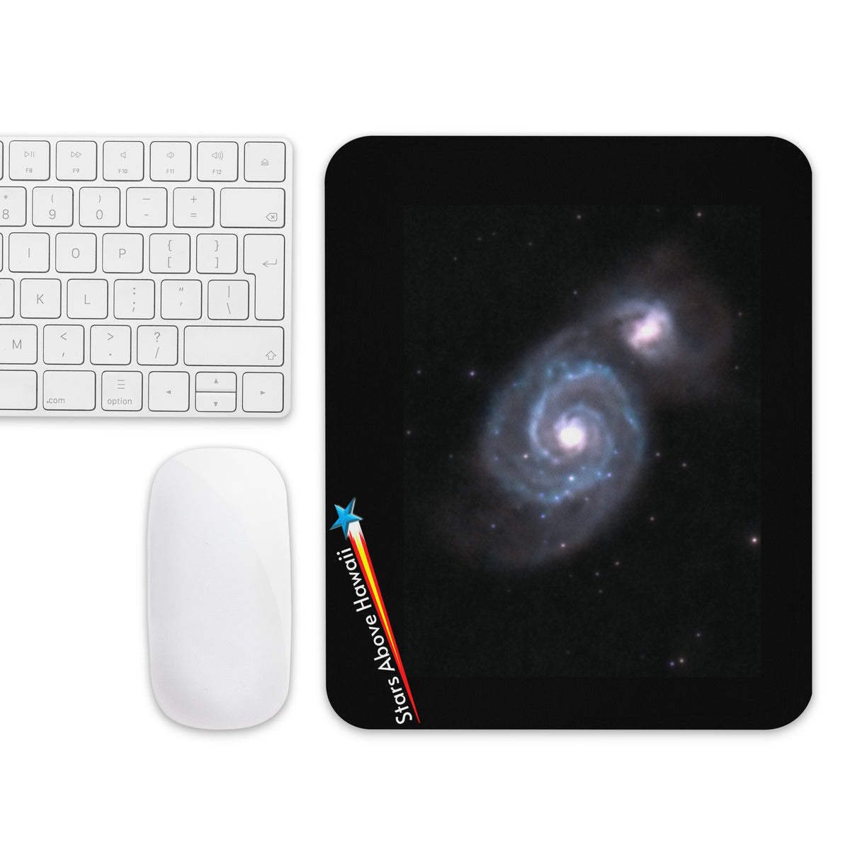 Whirlpool Galaxy mouse pad beside a keyboard and computer mouse on a desktop
