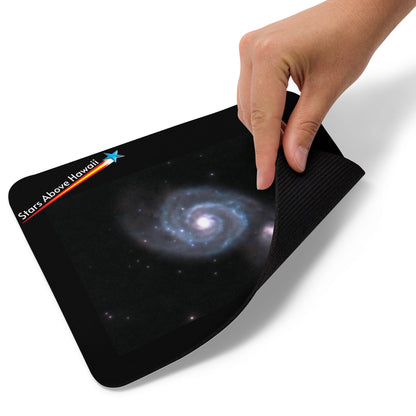 Whirlpool Galaxy mouse pad being lifted to show its flexible rubber-backed construction