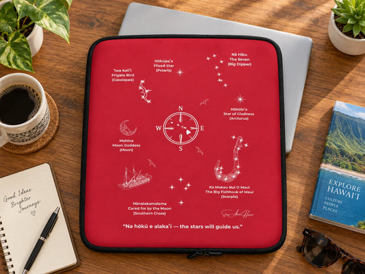 Red Hawaiʻi Star Navigation laptop sleeve with celestial wayfinding artwork beside a silver laptop on a wooden desk